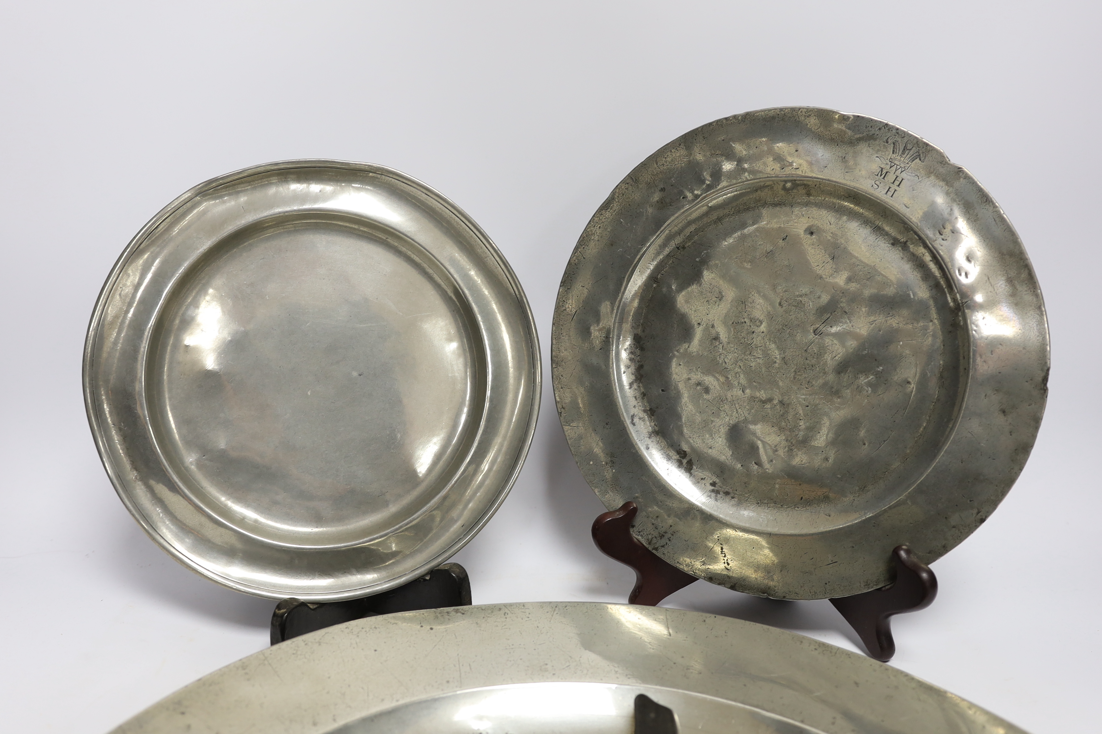 Four 18th century and later pewterware items including a charger, 41.5cm diameter, two plates, and a mug